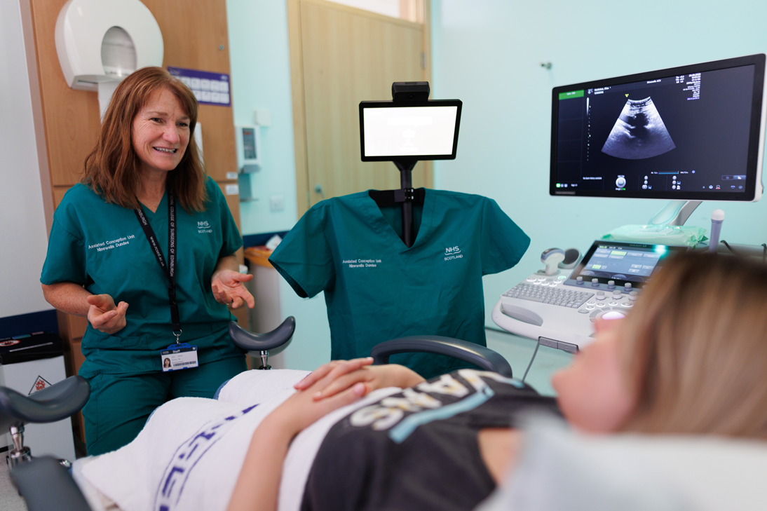 Photograph of a clinician and a remote consultation unit in conversation with a patient